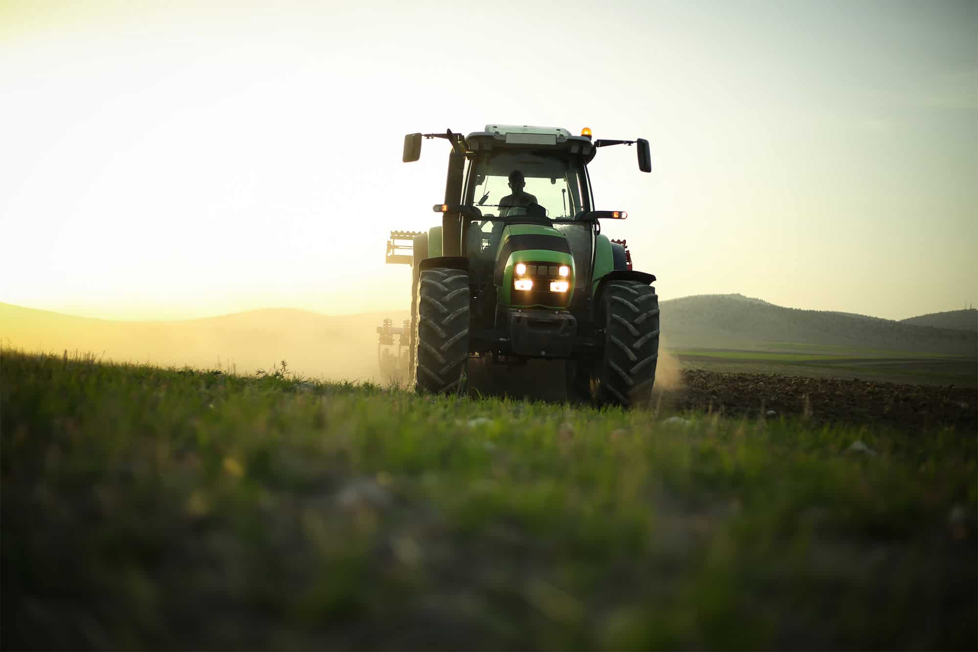 Tractor ploughing field at dusk